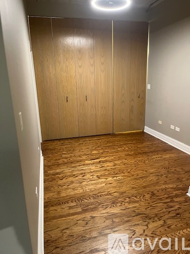 A room with wooden floors and a wall-mounted light fixture.
