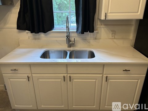 A white kitchen with a sink and cabinets.
