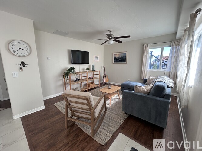 A living room with a couch, chair, and a television.