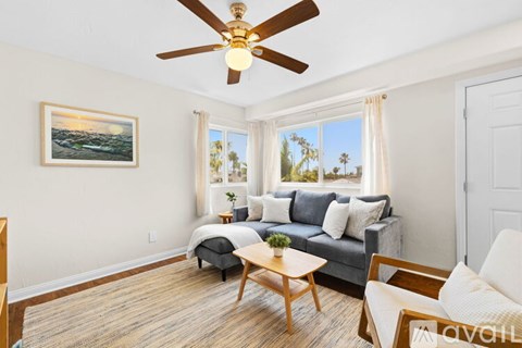 A living room with a couch, chair, and a television.