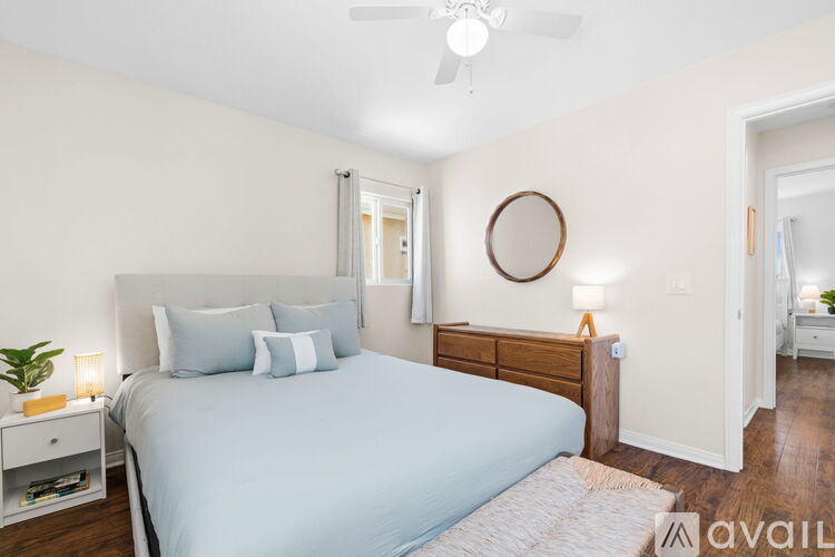A bedroom with a large bed and a ceiling fan.