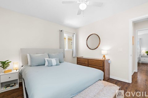 A bedroom with a large bed and a ceiling fan.