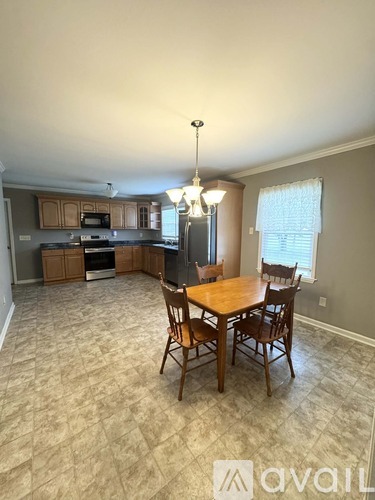 A kitchen with a dining table and chairs.