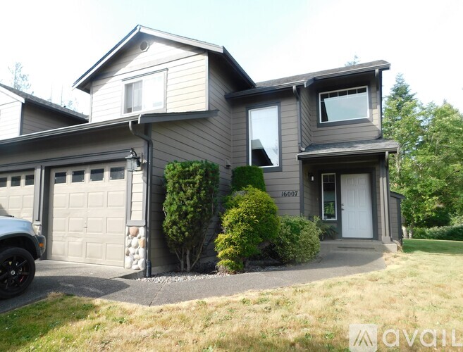 A two-story house with a garage and a driveway.