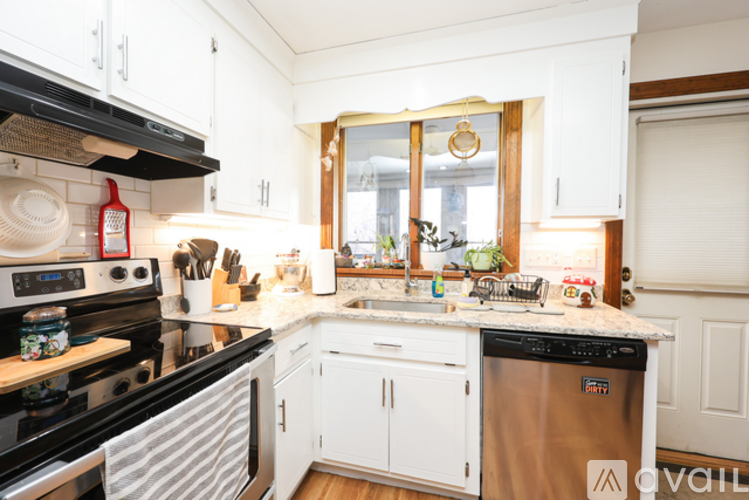 A kitchen with white cabinets and a black stove top oven.