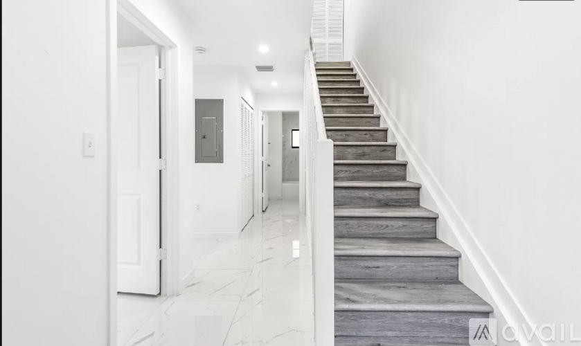A staircase with wooden steps and white walls.