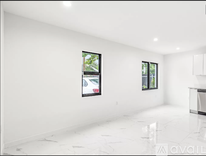 A spacious, white room with a marble floor and two windows.