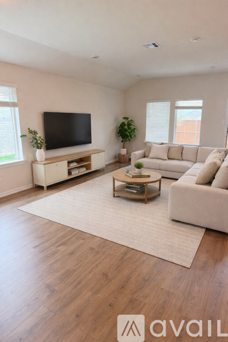 A living room with a television, couch, and coffee table.