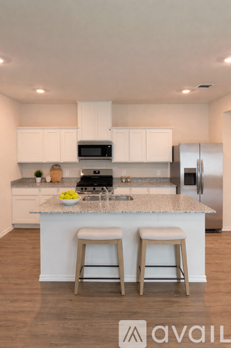 A kitchen with white cabinets and a granite countertop.