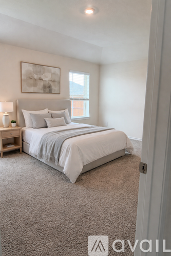 A bedroom with a large bed and a window.