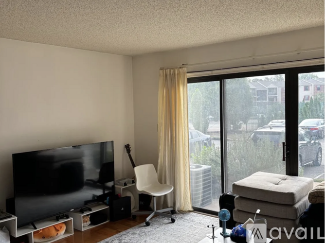 A living room with a television, chair, and sliding glass doors.