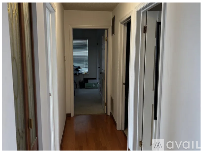 A hallway with a door on the left and another door on the right.