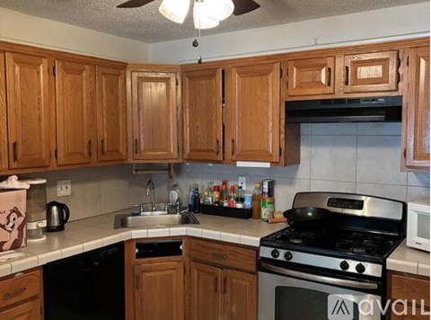 A kitchen with wooden cabinets and a black stove top oven.