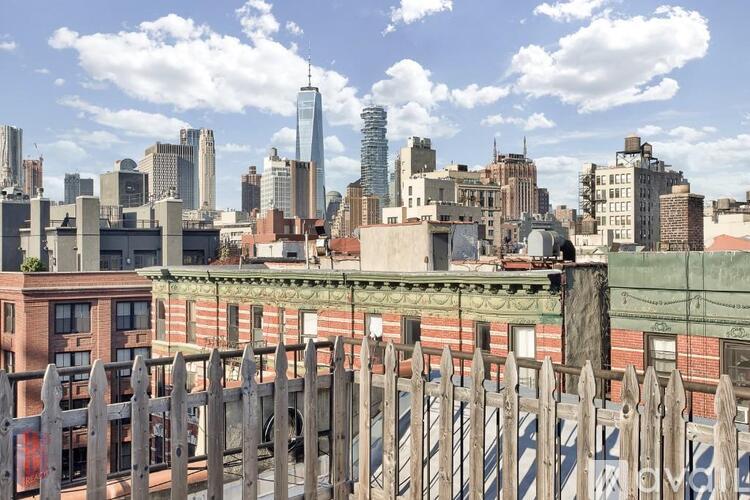A cityscape with a wooden fence in the foreground.