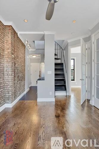 A spacious interior with a wooden floor and a brick wall.