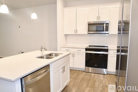 A kitchen with white cabinets and a white counter top.
