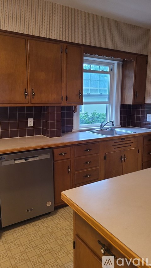 A kitchen with wooden cabinets and a dishwasher.