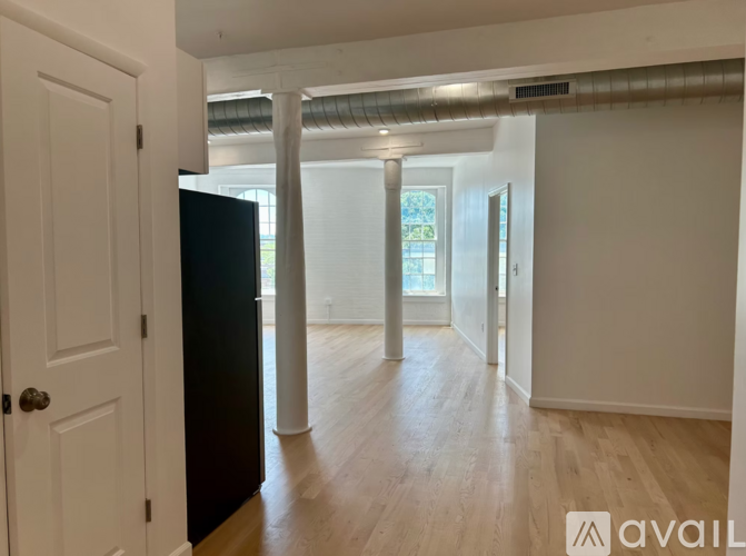 A room with a black door and wooden flooring.