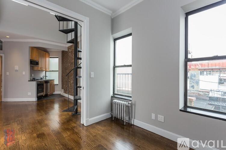 A spacious living room with a staircase leading to the upper floor.