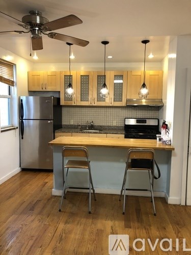 A kitchen with wooden cabinets and a stainless steel refrigerator.
