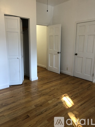 A room with white doors and wooden floors.