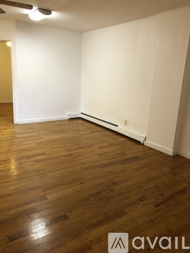 A room with wooden flooring and white walls.