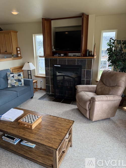 A living room with a fireplace, a couch, a chair, and a coffee table.