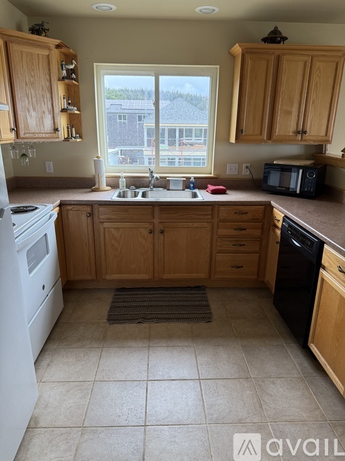 A kitchen with wooden cabinets and a white dishwasher.