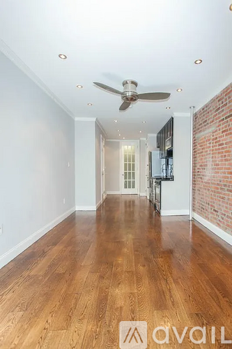 A room with wooden floors and a ceiling fan.