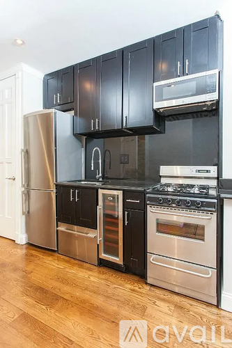 A kitchen with black cabinets and stainless steel appliances.