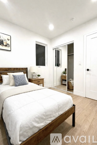 A bedroom with a large bed and a wooden headboard.