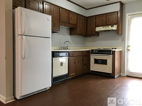 A kitchen with a white refrigerator and wooden cabinets.