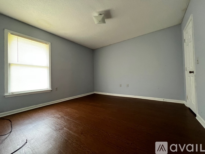 A room with a window and wooden floor.