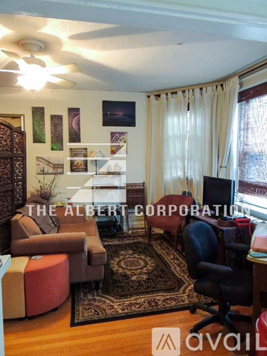 A living room with a rug, a chair, and a couch.