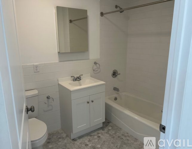 A white bathroom with a toilet, sink, and bathtub.