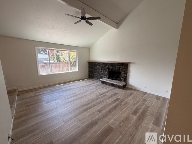 A room with a fireplace and a ceiling fan.