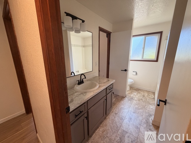 A bathroom with a sink, mirror, and toilet.