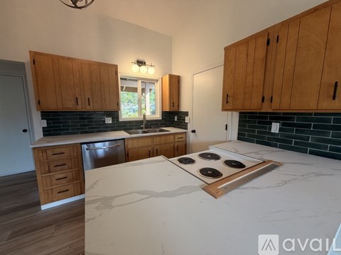 A kitchen with wooden cabinets and a marble countertop.