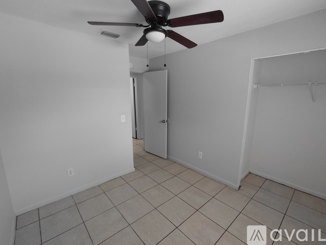 A room with a ceiling fan and tiled floor.
