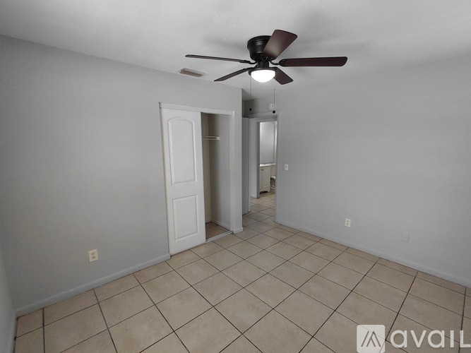 A room with a ceiling fan and tiled floor.