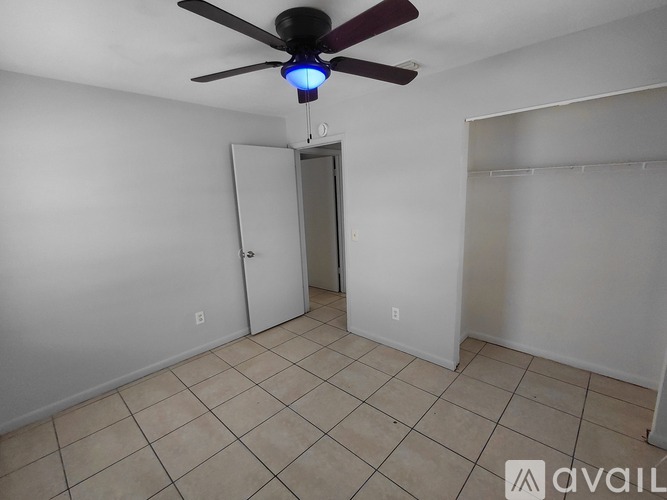 A room with a ceiling fan and a doorway leading to another room.