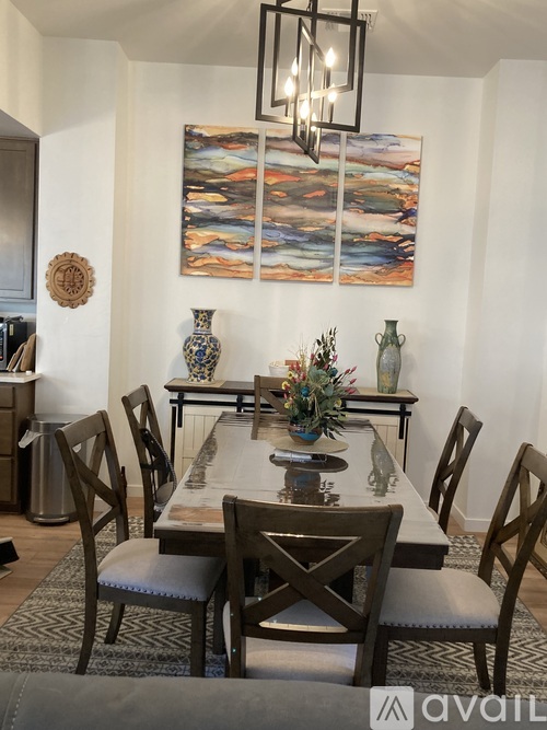 A dining room with a wooden table and chairs.