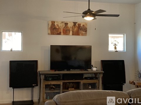 A living room with a television and two large speakers.
