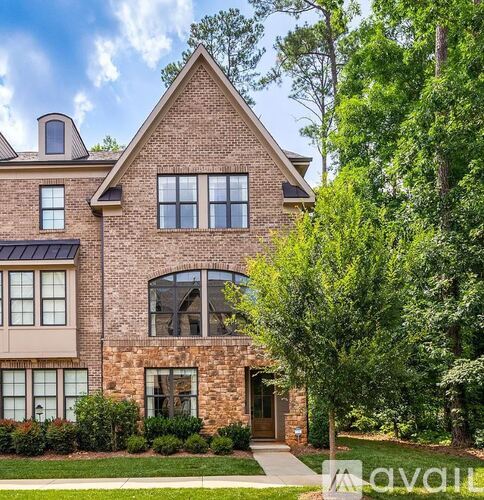 A large brick house with a large front yard.