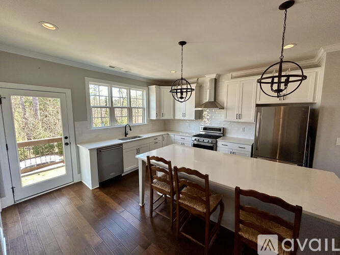 A kitchen with wooden floors and white cabinets.