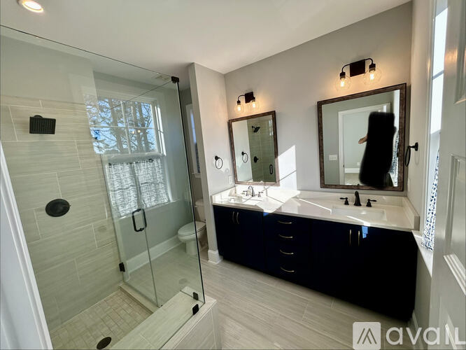 A bathroom with a walk-in shower and a vanity with a mirror.
