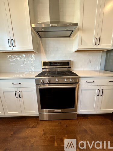 A kitchen with white cabinets and a stainless steel oven.