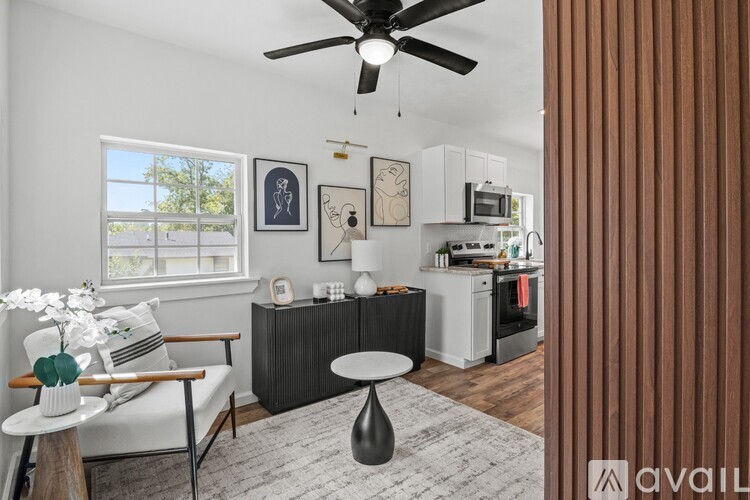 A living room with a ceiling fan and a dining area in the background.