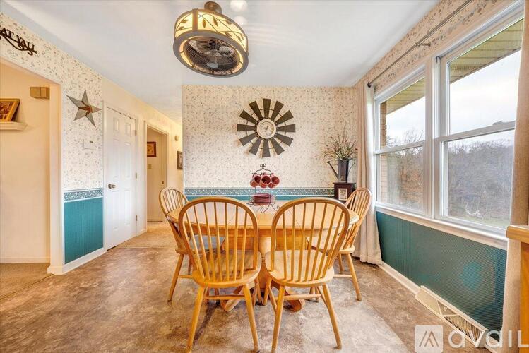 A dining room with a wooden table and chairs.