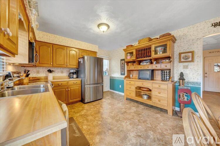 A kitchen with wooden cabinets and a stainless steel refrigerator.